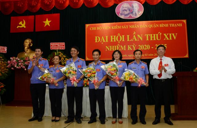 Đồng chí Mai Trung Thành (trái) và đồng chí Vũ Ngọc Tuất (phải) tặng hoa chúc mừng cấp ủy Chi bộ Viện Kiểm sát nhân dân quận nhiệm kỳ 2020 - 2025. (Ảnh: VM)