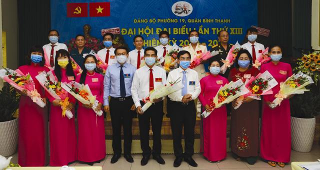 Lãnh đạo thành phố và quận tặng hoa chúc mừng Ban Chấp hành Đảng bộ Phường 19 nhiệm kỳ 2020 - 2025. (Ảnh: VM)